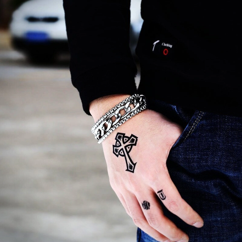 Double-chain stainless steel bracelet worn on male tattooed wrist outdoors, side close-up street background showcasing silver polished punk aesthetic