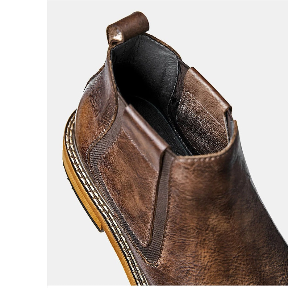 Closeup ankle seam detail of black leather Chelsea boot, elastic side panel construction