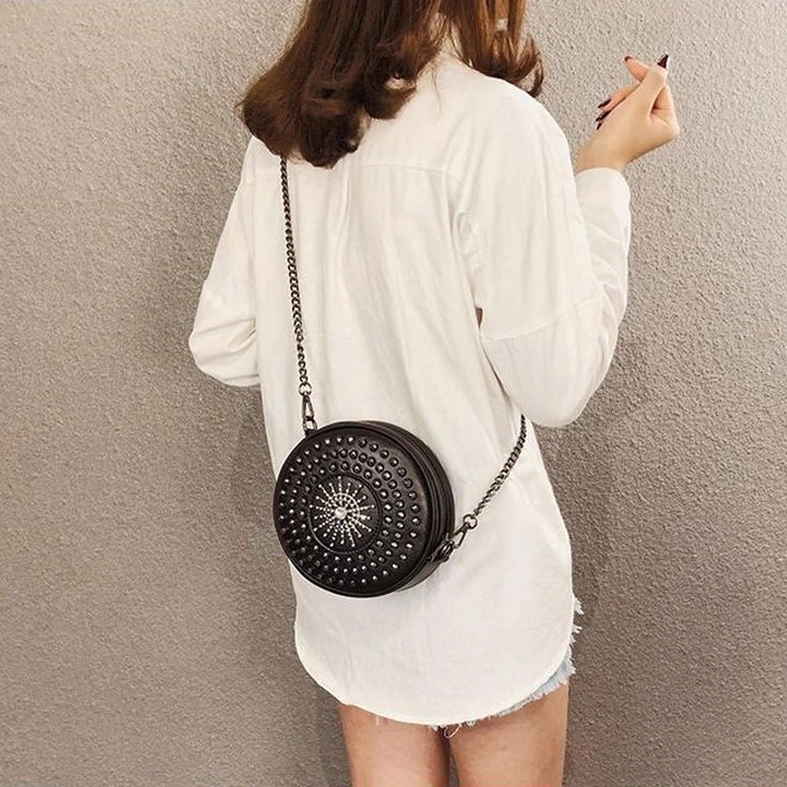 Back view of woman wearing black gothic studded circle crossbody bag, showing rear wear effect and styling