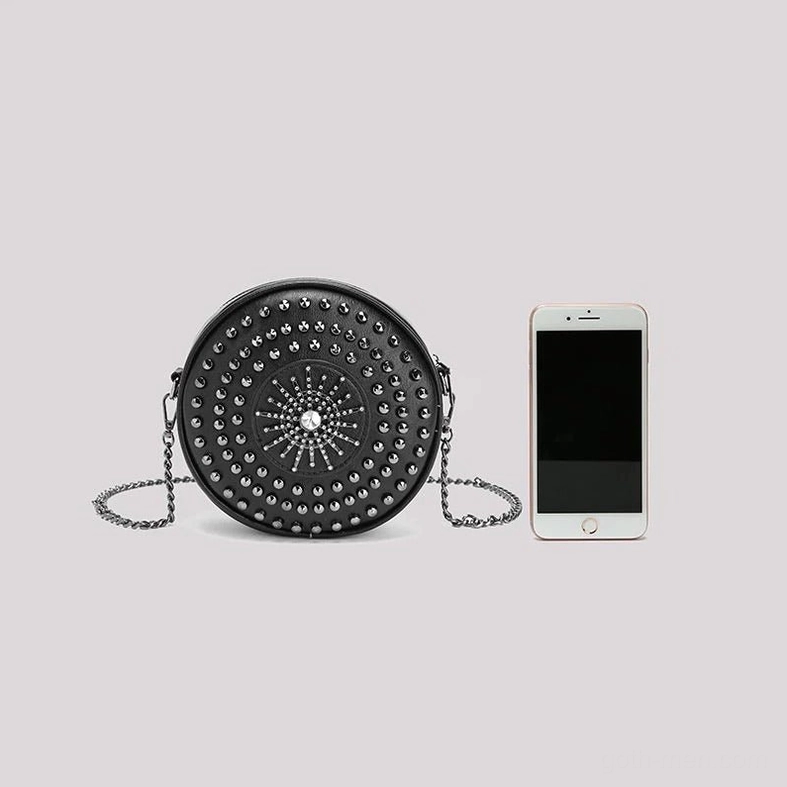 Black studded round gothic bag size comparison with smartphone showing compact portable design