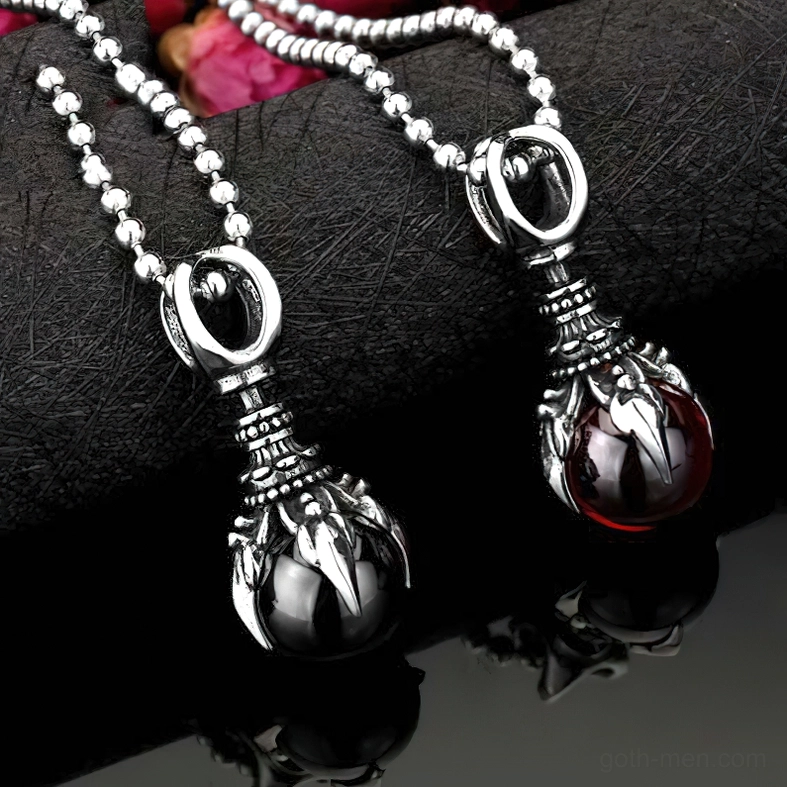 Multiple gothic claw stone pendants styled together on dark fabric, close-up detail shot
