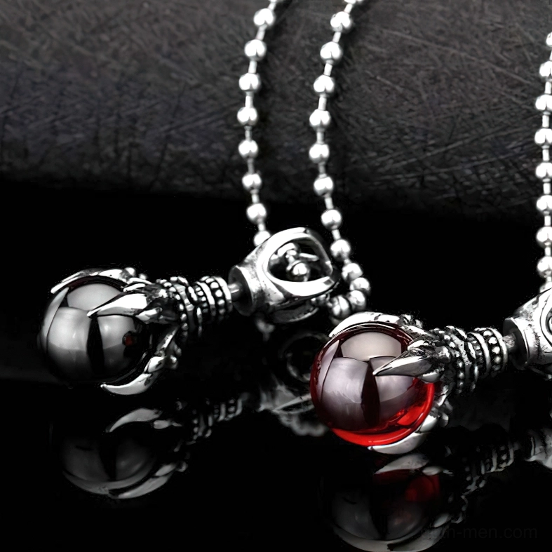 Gothic claw stone pendants close-up on reflective black surface, highlighting design details