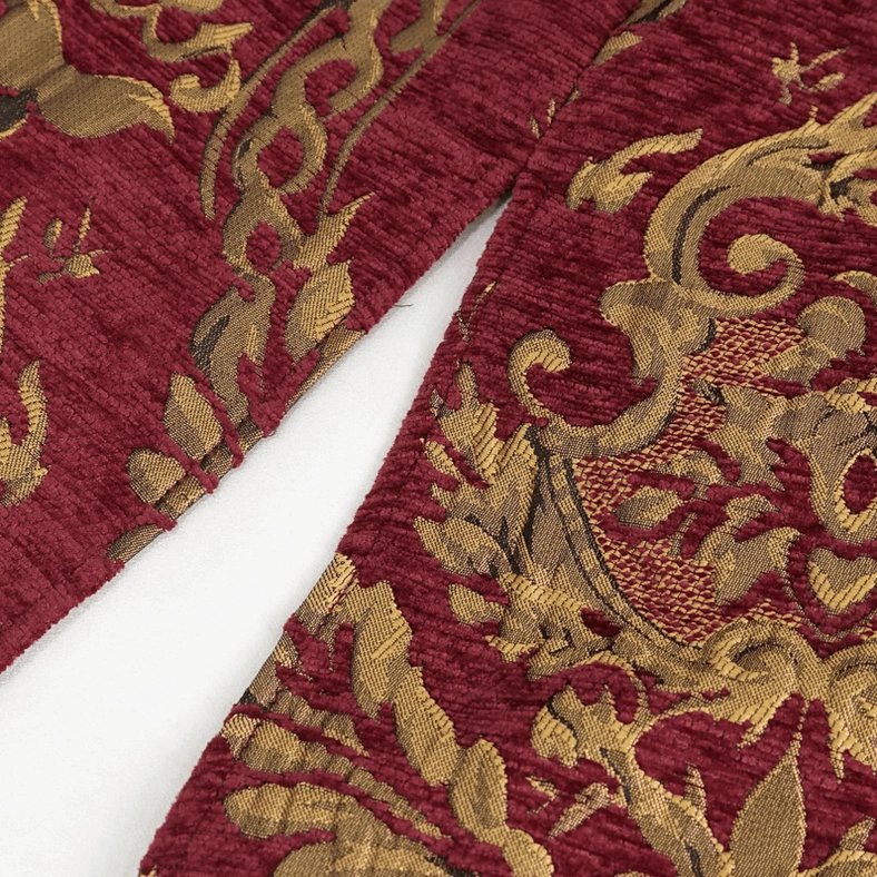 Close-up of gothic coat front split hem detail showing neatly stitched seam and consistent gold damask pattern across garment edges
