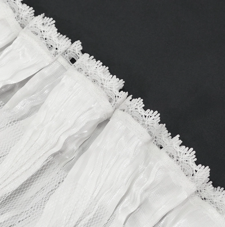 Macro close-up detail of white ruffled mesh fabric with delicate scalloped lace trim on gothic collar