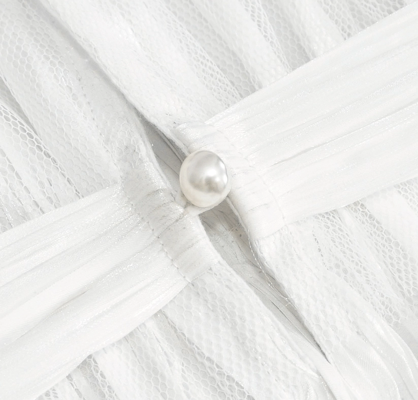 Top-down macro detail of white gothic collar closure showing single pearl button fastener and pleated texture