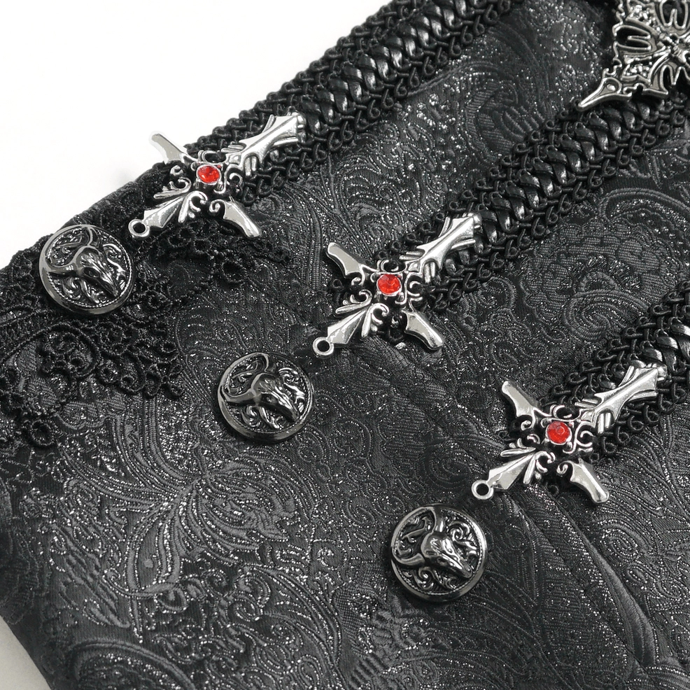 Close-up detail of black brocade gothic corset showing ornate silver cross pendant and zipper hardware