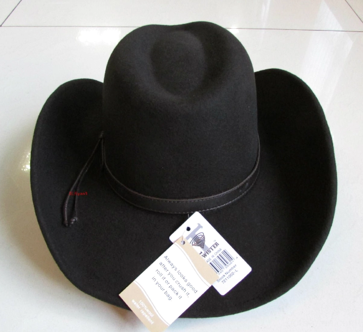 Black wool gothic cowboy hat with braided leather band and metal studs, three-quarter view with price tag