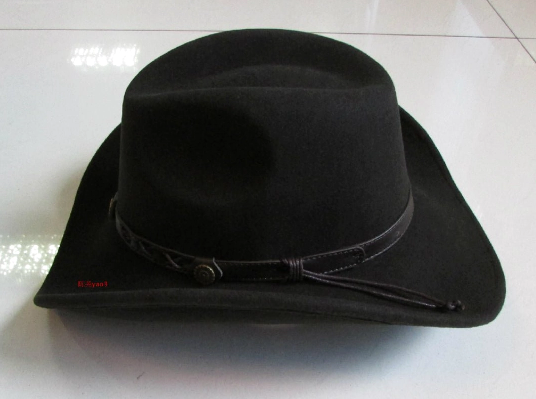 Wide brim black cowboy hat with plain leather band and metal fastener, right side profile