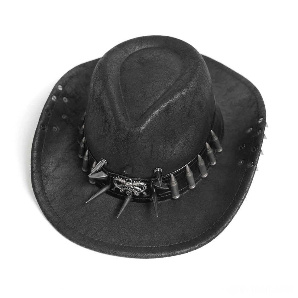 Flat lay overhead view of black gothic cowboy hat showing metal skull, bullet and spike trim decorations against studio background