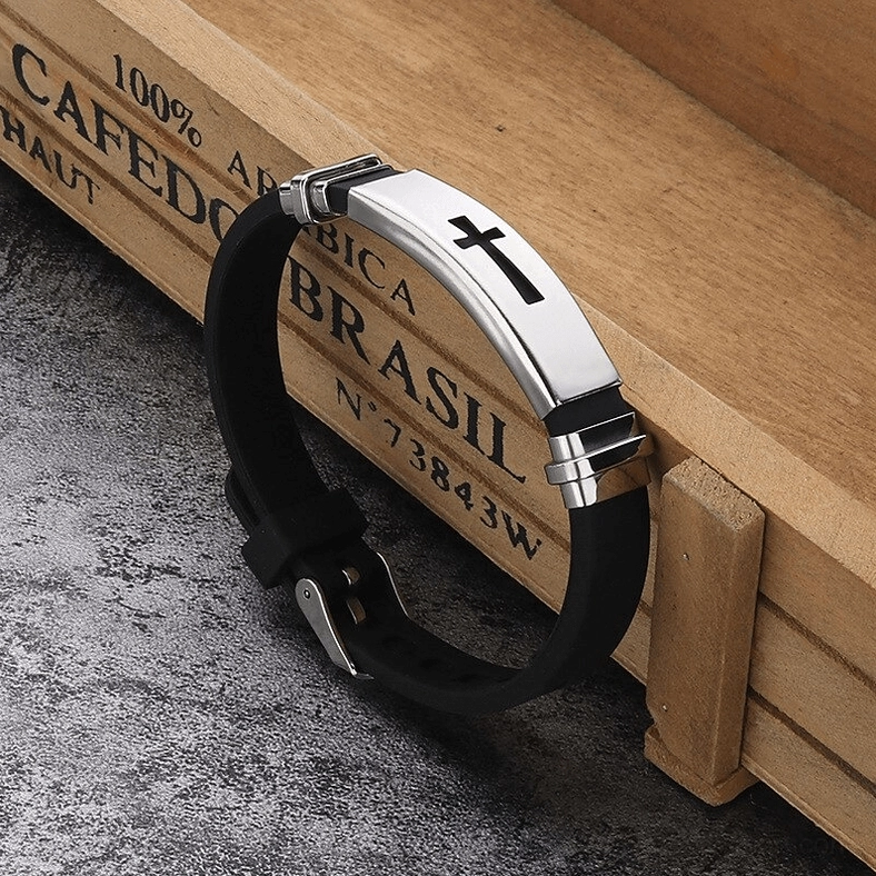 Gothic cross titanium steel silicone bracelet with polished silver cross plate and double-safety metal buckle clasp on wooden crate