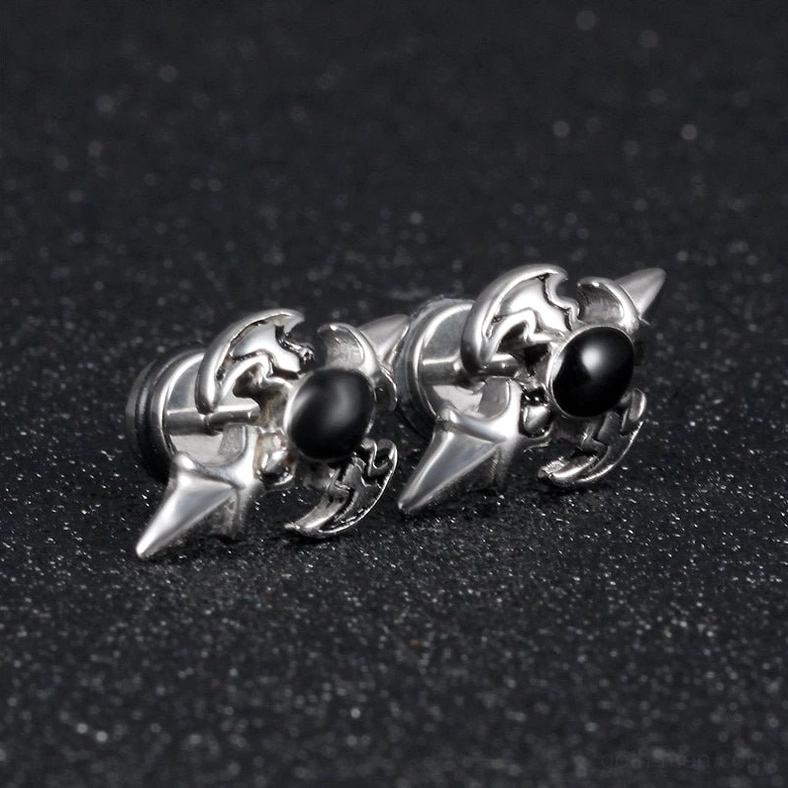 Silver gothic cross spike earring spiked silhouette close-up - side view on dark textured background