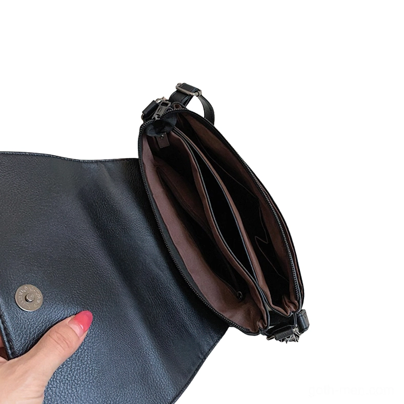 Gothic crossbody bag interior compartment close-up showing magnetic snap and brown polyester lining with multiple pockets