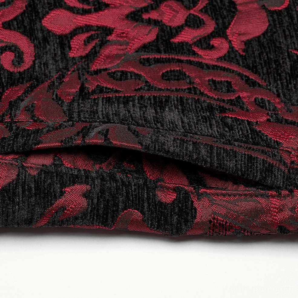 Fabric texture close-up of gothic damask waistcoat, showing densely woven jacquard pattern with ornate red and black floral scroll design and intricate baroque detailing