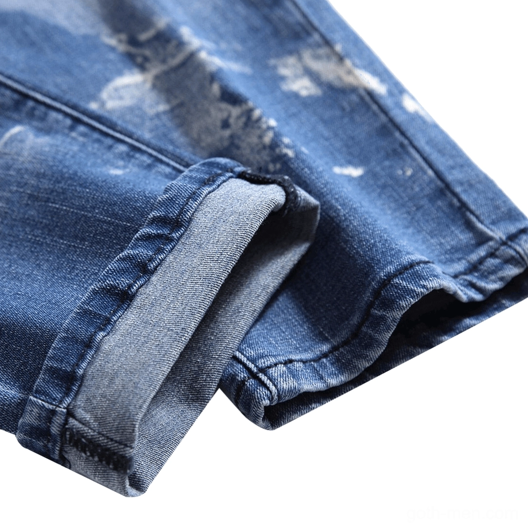 Rolled cuff detail of acid-washed blue gothic denim jeans showing fabric texture