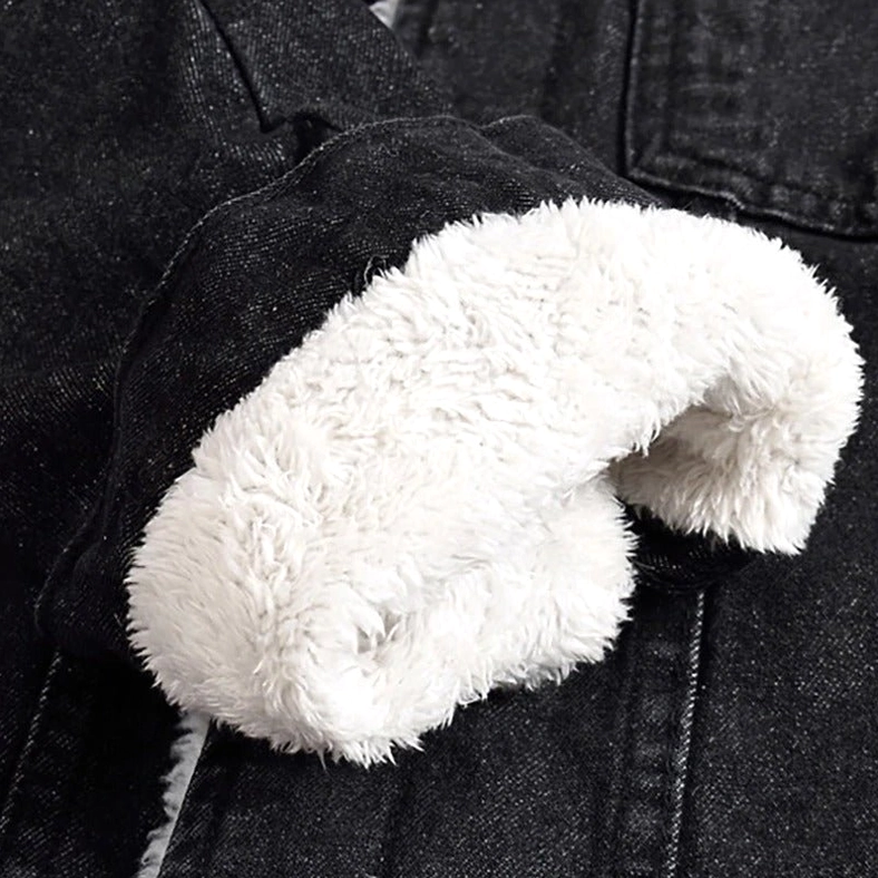 Black denim jacket cuff detail showing white sherpa fleece lining contrast, gothic winter warmth construction