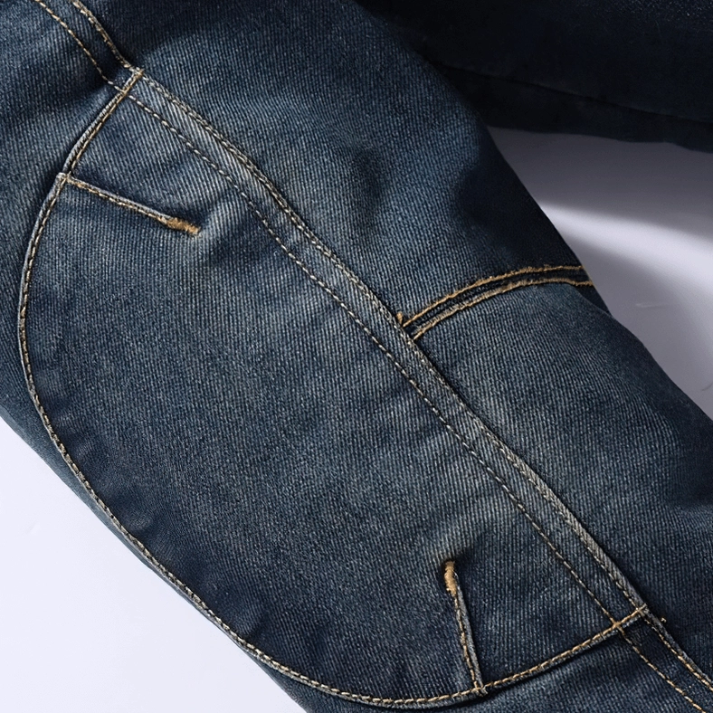 Close-up of men's gothic denim jacket side pocket, dark wash denim fabric, contrast stitching, metal reinforced pocket rivets