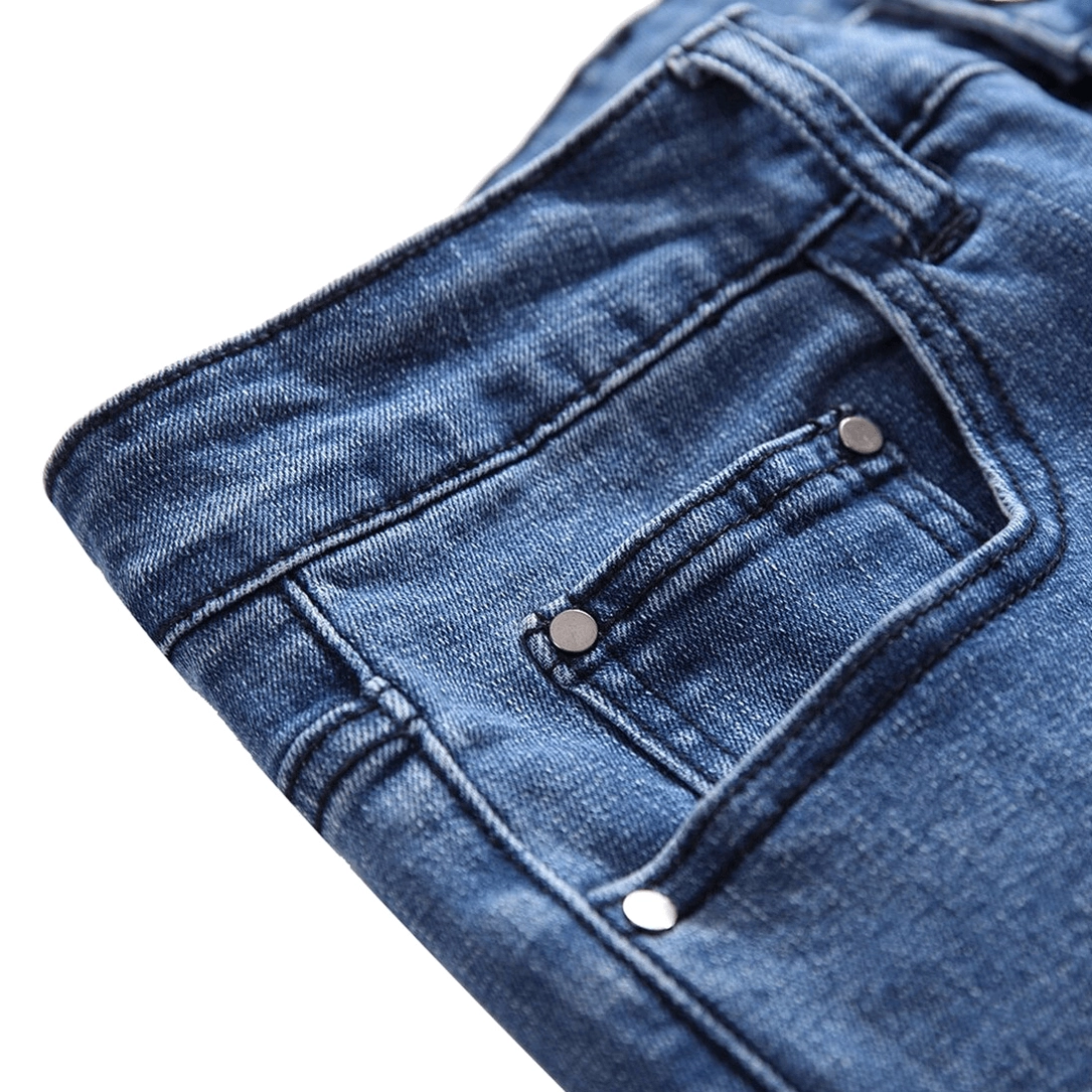 Metal button fly and waist construction detail of gothic blue denim jeans closeup