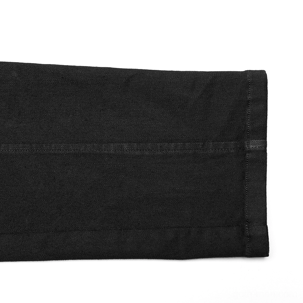 Top-down close-up detail of black denim hem and fabric texture on gothic slim-fit pants