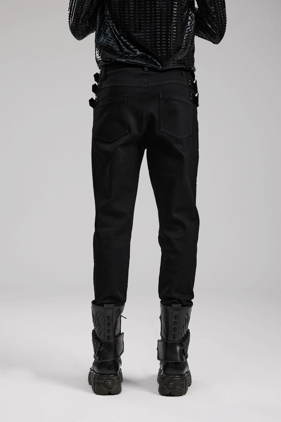 Product photography showing black gothic denim pants overall construction and metal stud placement