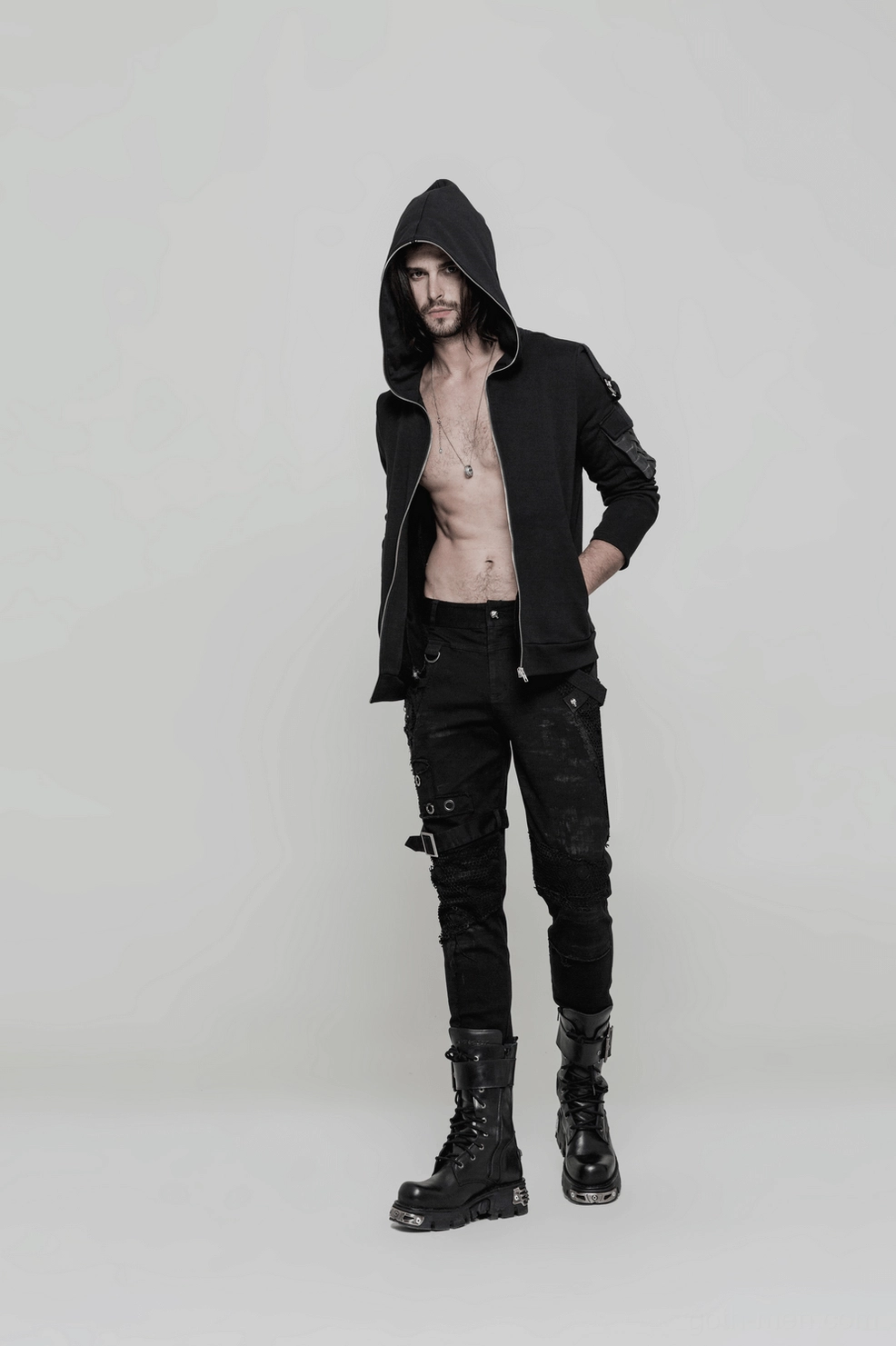 Waistband and front opening detail of gothic distressed black jeans with adjustable metal buckle strap