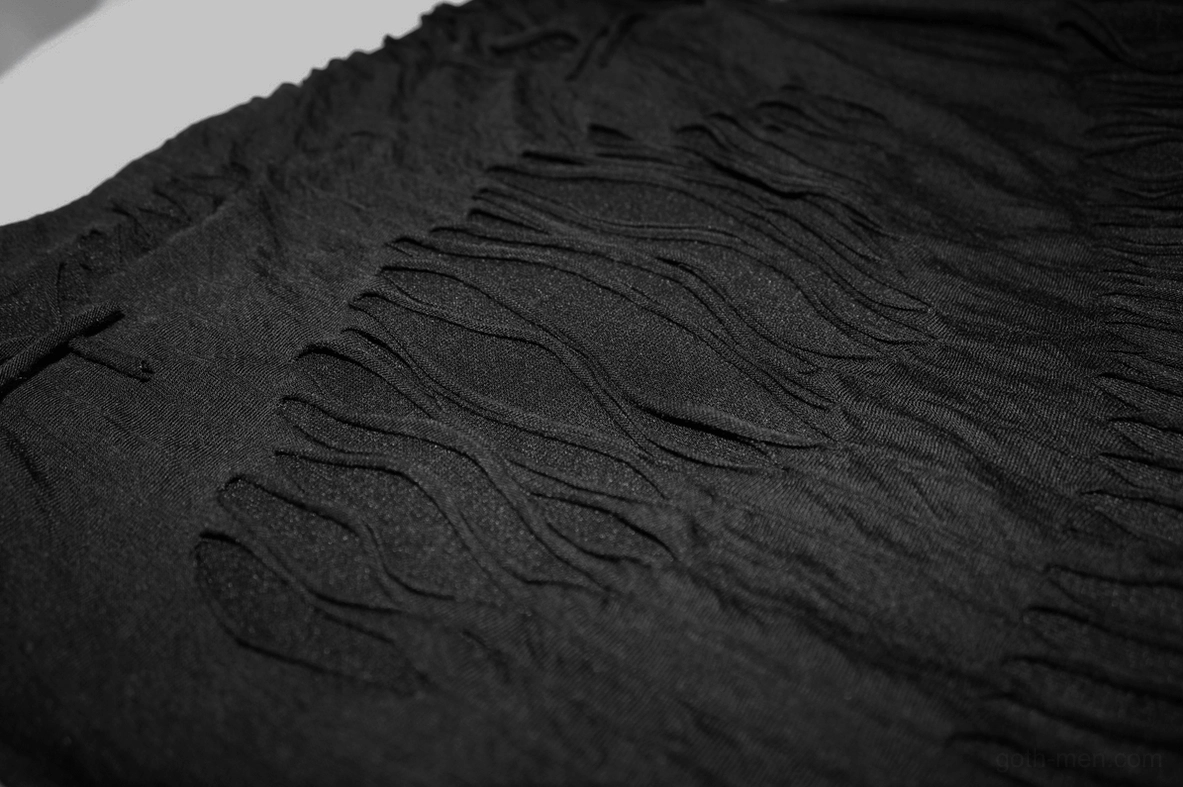 Gothic fringe t-shirt construction detail - shredded wave fabric texture with layered mesh and metal stud reinforcement