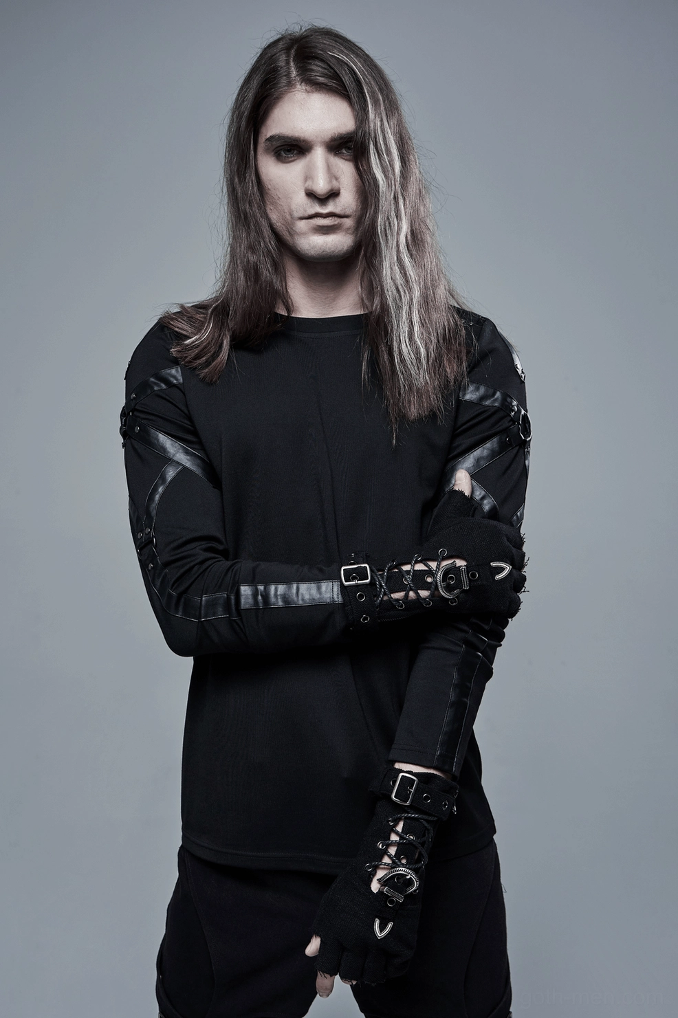 Male model wearing gothic fingerless gloves with dark streetwear ensemble, front view showing hardware details