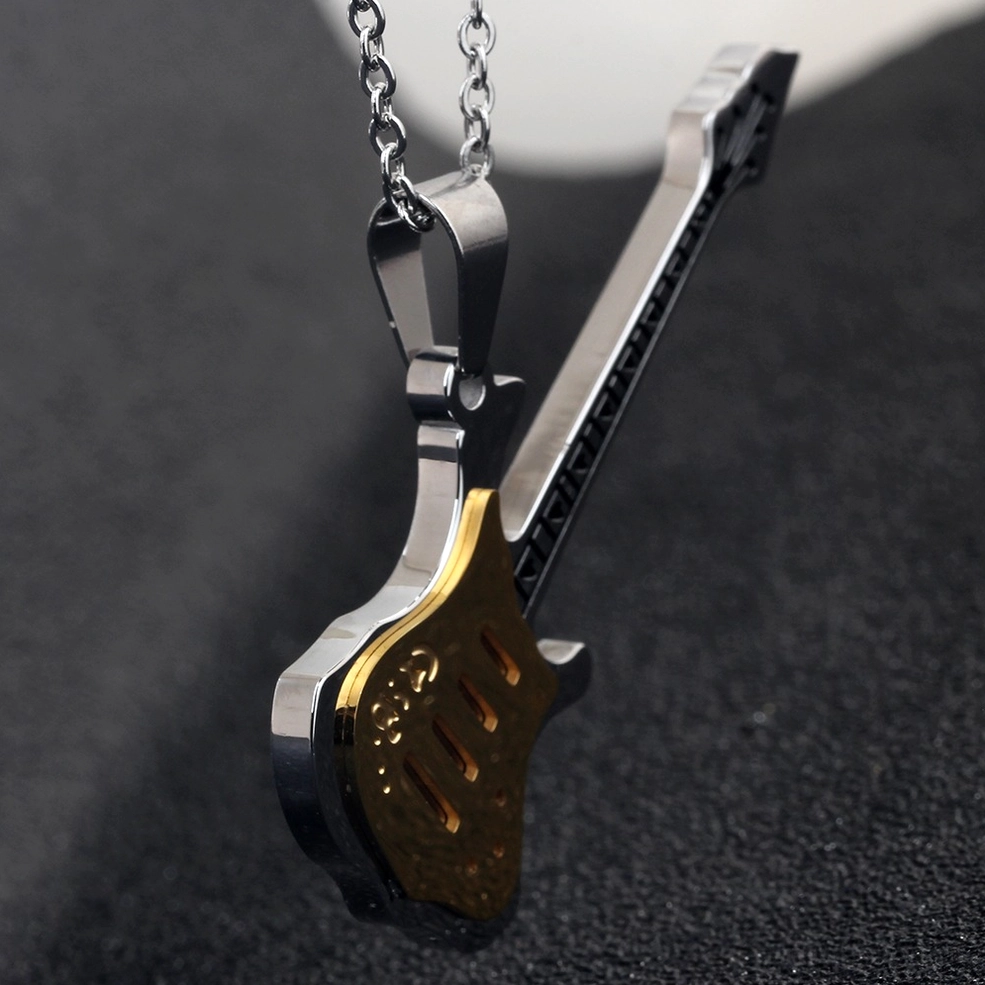 Close-up side view of two-tone guitar pendant with polished silver and gold details on dark background