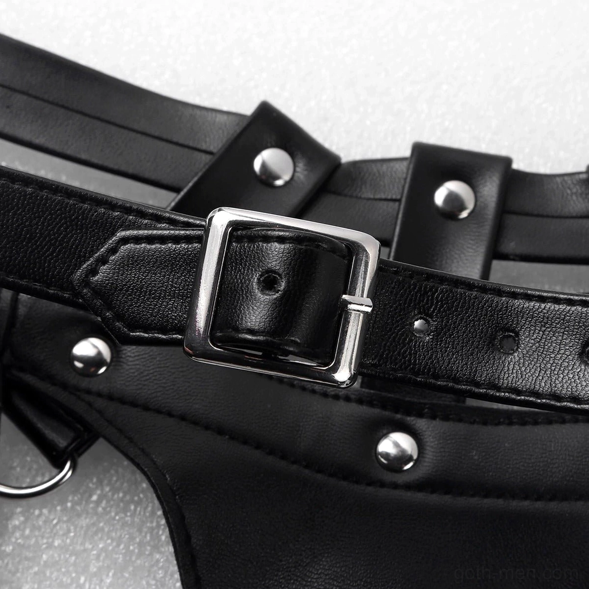 Silver square buckle and metal rivets close-up on matte faux leather texture with D-ring attachment hardware