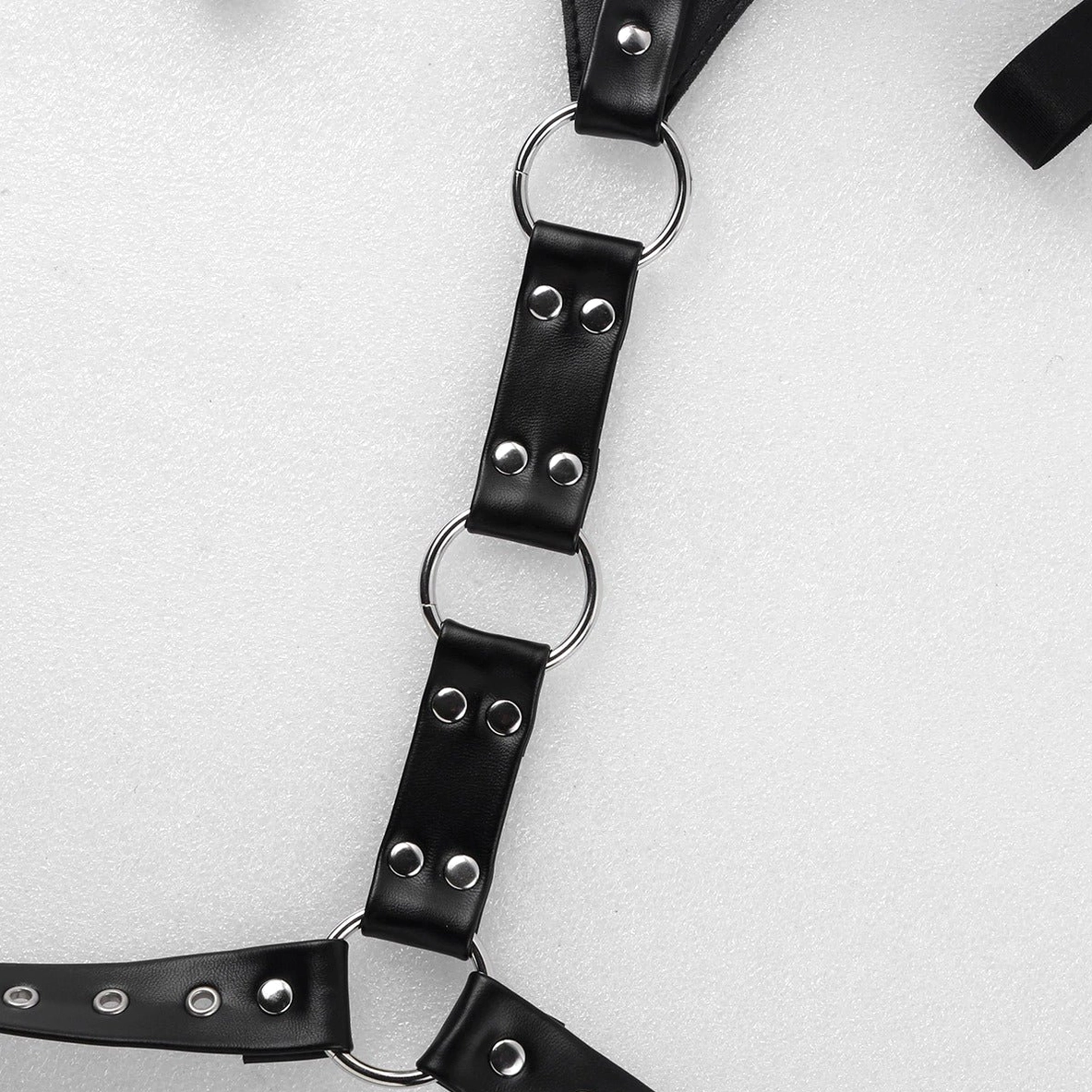 Close-up of metal O-rings and double-rivet fixed leather straps showing adjustable length design and hardware precision
