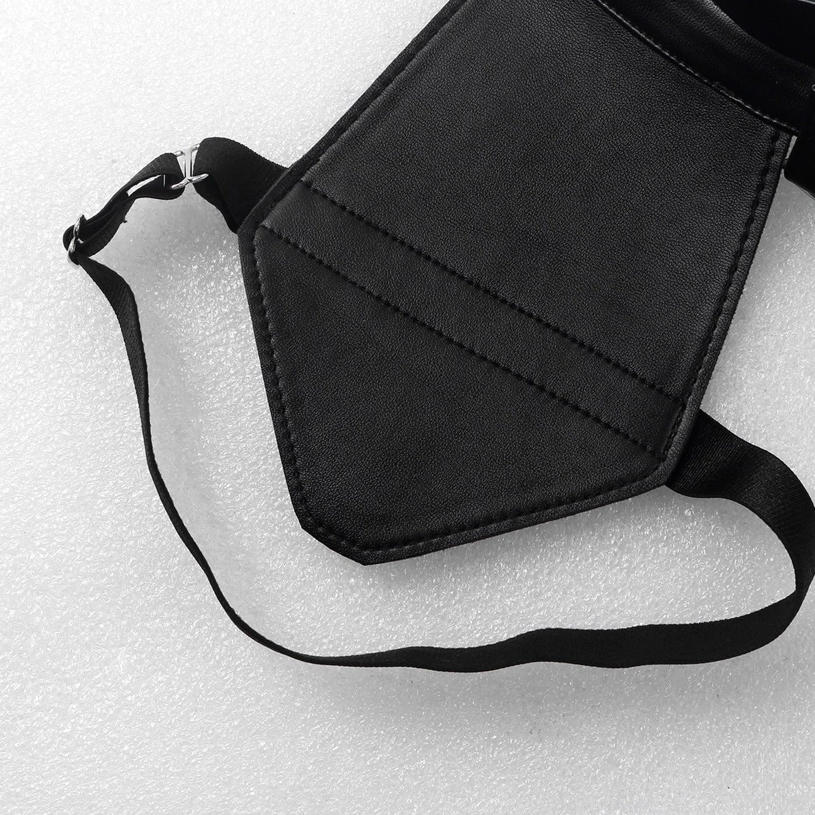 Shoulder pad and strap detail highlighting faux leather texture, stitched edges, and adjustable fabric strap construction