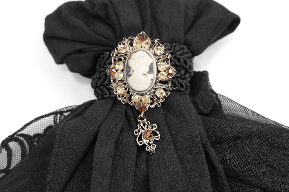 Vintage black oval cameo brooch with gold toning, crystal accents and dangling charm for gothic jabot