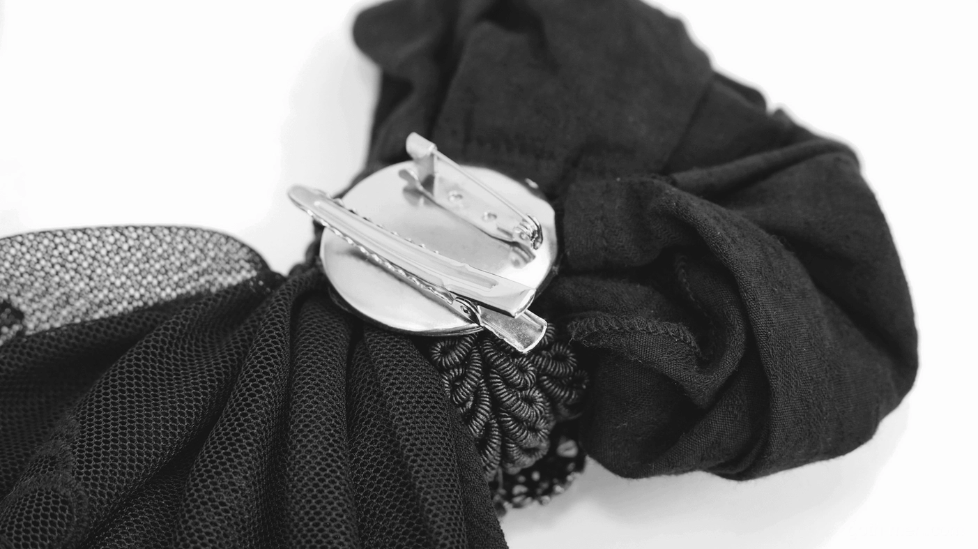 Silver-toned spring clip buckle fastener for gothic jabot brooch attachment mechanism close-up