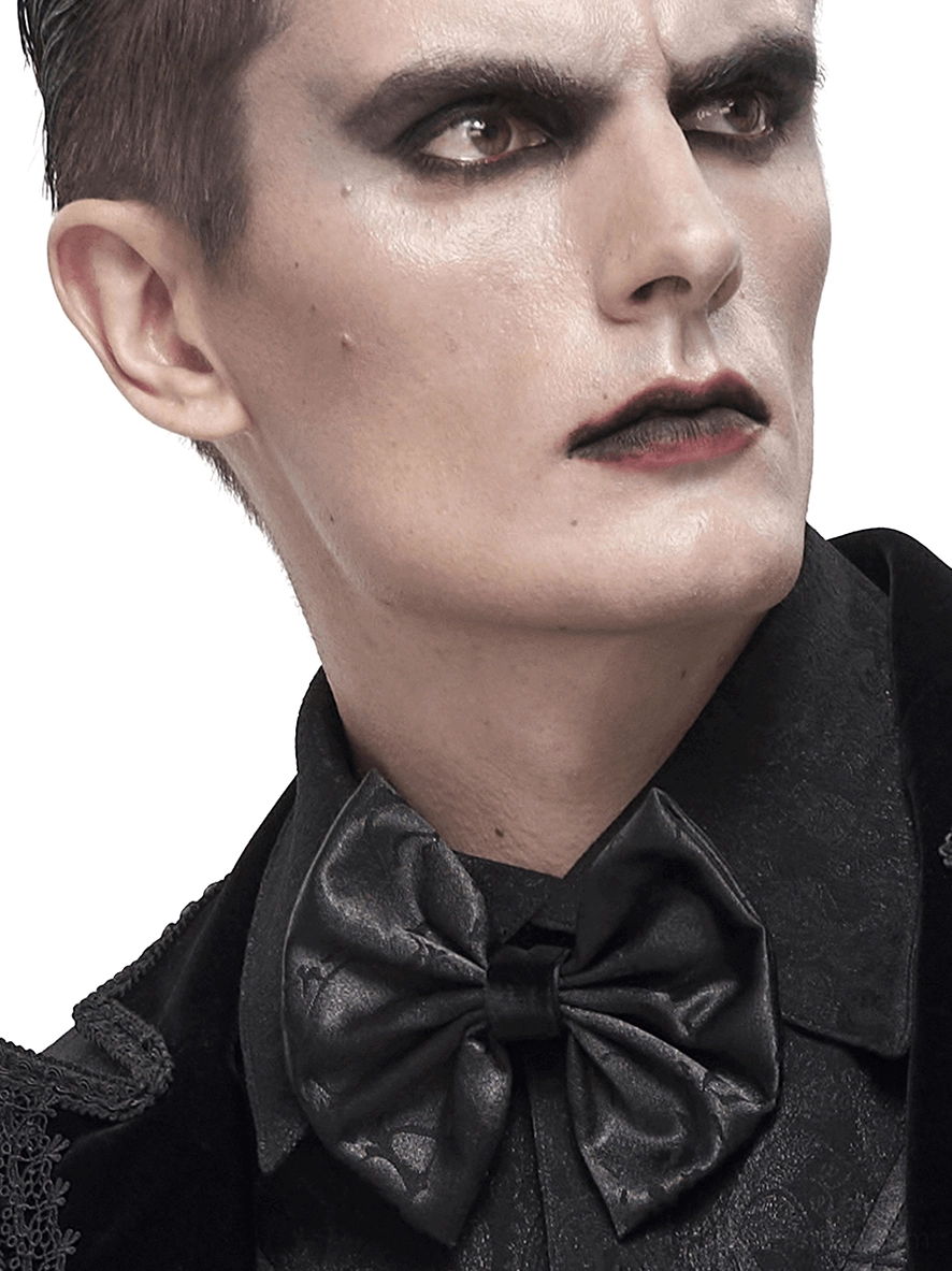 Male model wearing black jacquard gothic bow tie with lace-up design on formal black shirt, three-quarter studio portrait view