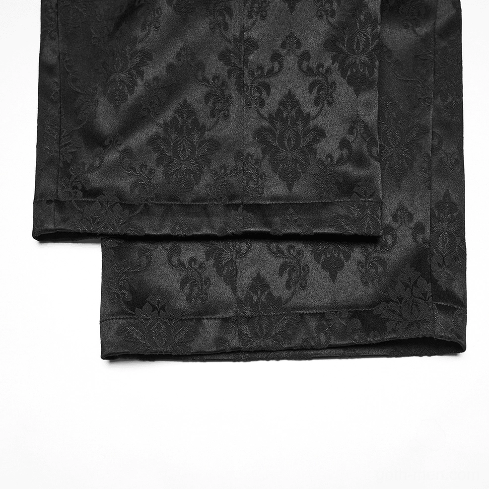 Close-up of black gothic jacquard trouser leg hems with floral damask pattern and satin-like finish