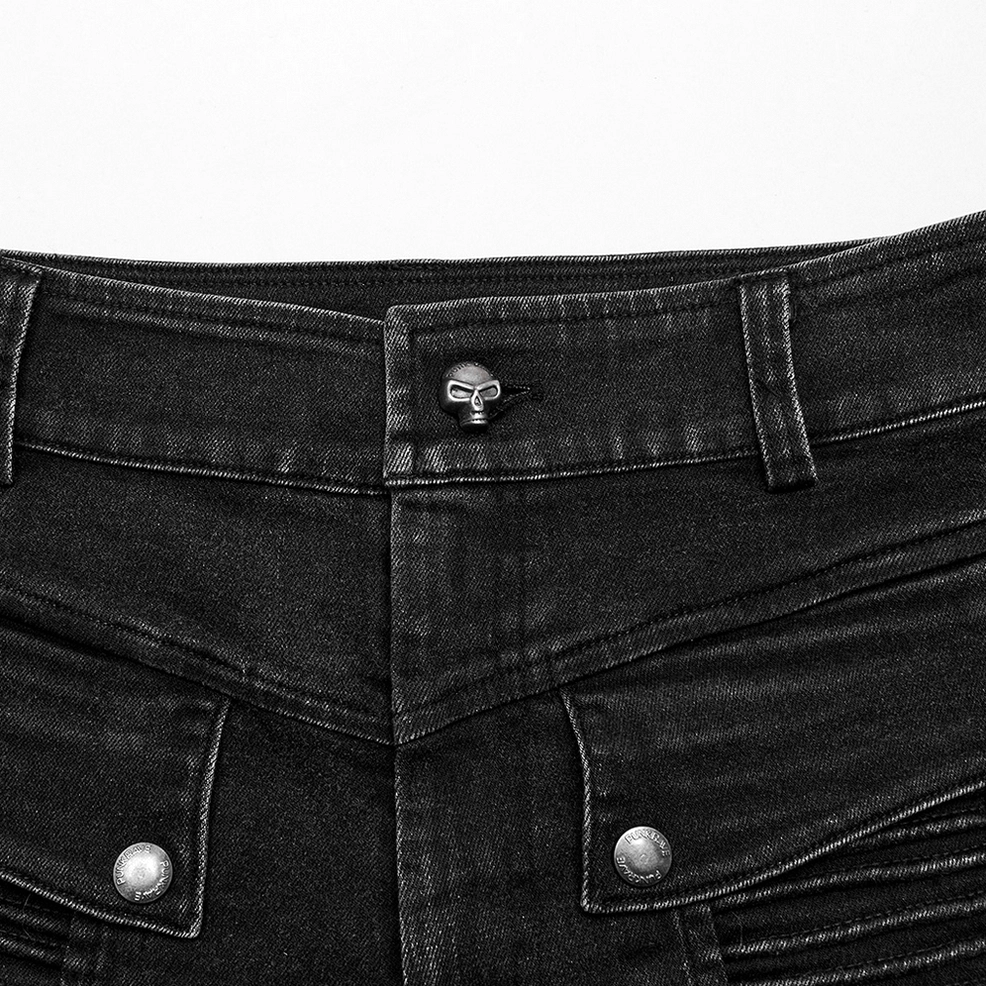 Gothic skinny jeans hardware close-up - skull-shaped metal button, snap fasteners on black washed denim