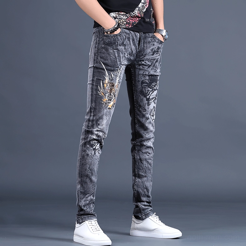 Three-quarter front angle of gothic embroidered denim jeans showcasing slim tapered fit and fabric quality