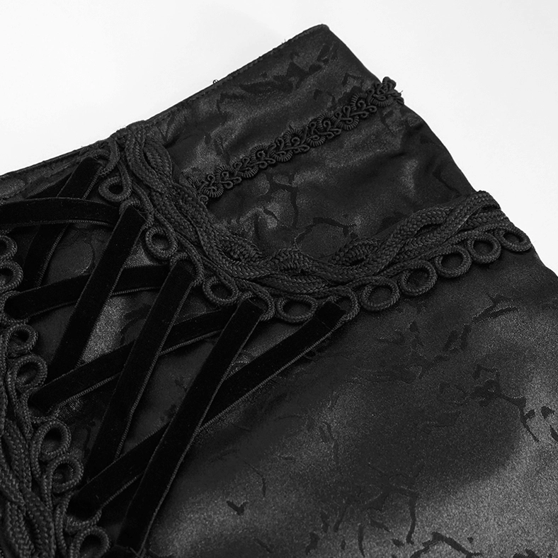 Top-down close-up of black gothic cargo pants waist lace-up trim showing ornate braided velvet gothic detail
