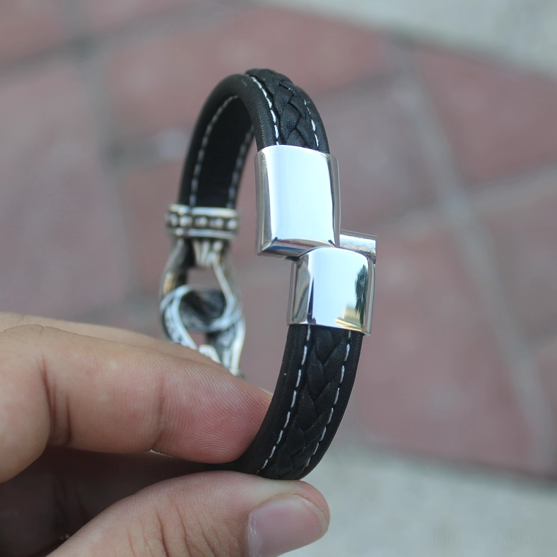 Rear view of magnetic snap closure on braided leather gothic men's bracelet held in hands