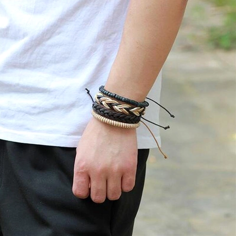 Male model wearing stacked 4-piece gothic leather bracelet set on wrist outdoor street view showing real-world styling
