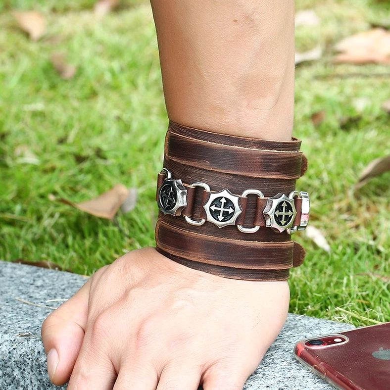 Brown leather gothic punk bracelet worn on wrist, real-life styling outdoor scene, alternative fashion
