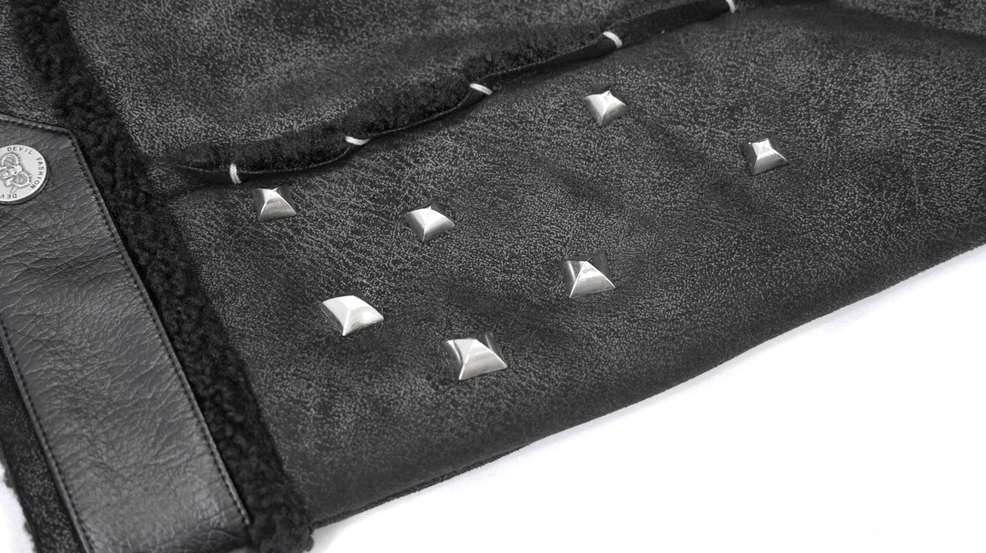 Macro detail showing black PU leather fabric texture with pyramid metal studs and fasteners