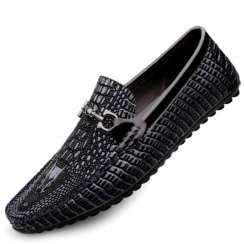 Black leather gothic slip-on loafers featuring crocodile embossing and metal decorative buckle, side angle view on white background