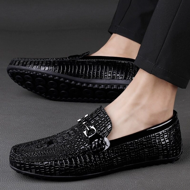 Male model wearing black crocodile embossed gothic loafers with formal trousers, on-feet three-quarter side view styling
