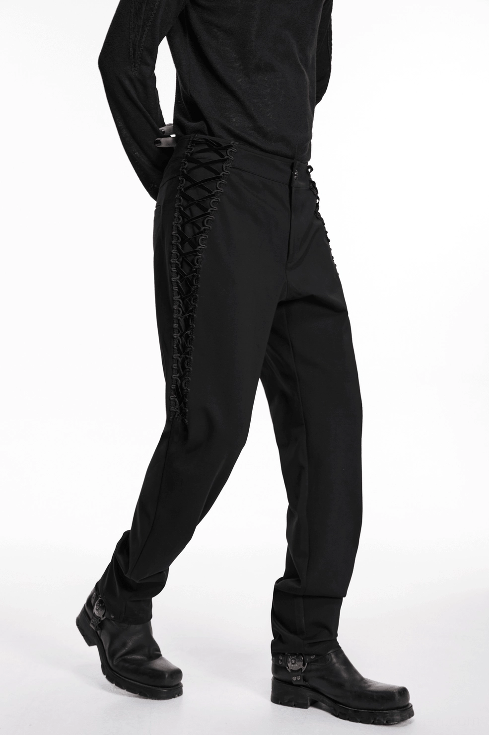 Angled view of gothic black slim-fit pants highlighting the architectural side lace-up design element