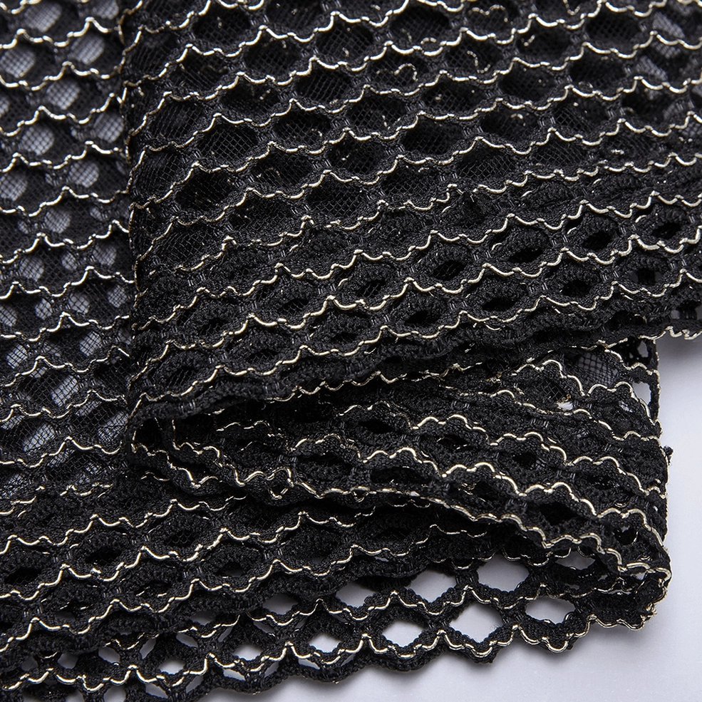 Macro detail shot of honeycomb mesh texture with gold trim and woven pattern on gothic tank top fabric