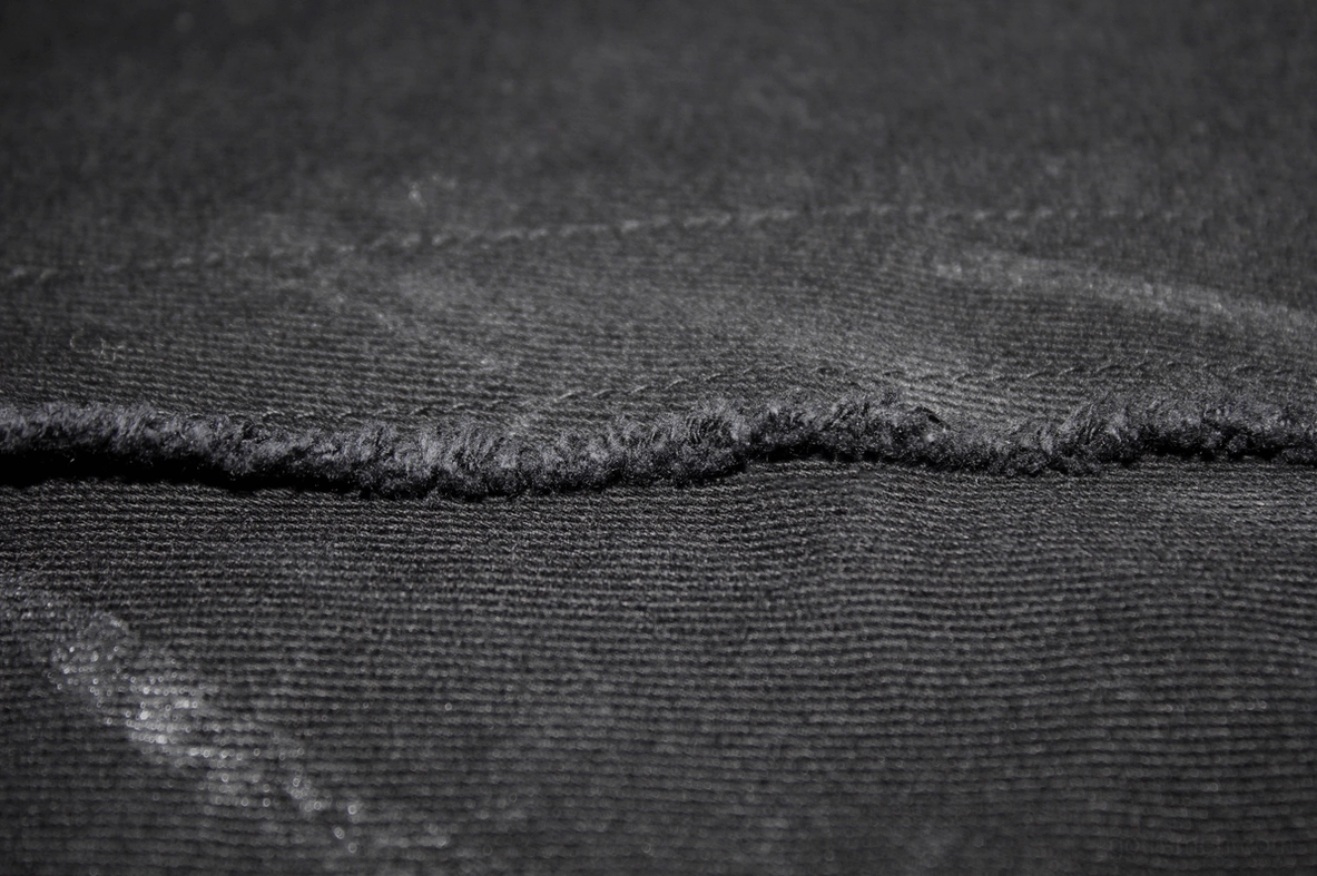 Side view detail of black slim-fit gothic trousers showing pocket construction and paint finish