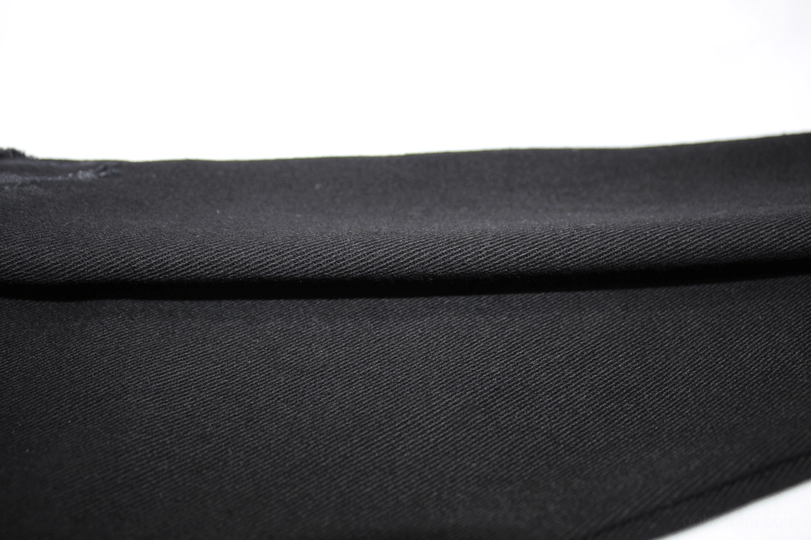 Detailed perspective of black gothic pants showing architectural slim cut and distressed surface