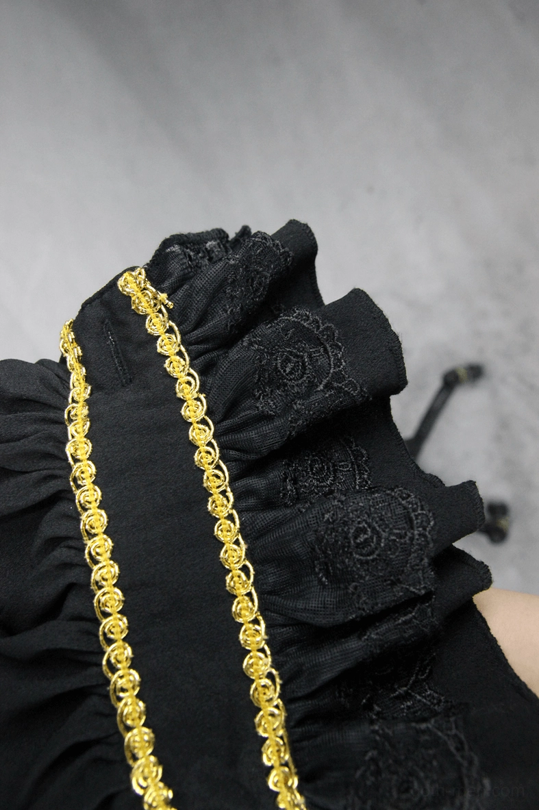 Close-up detail of black ruffled cuff with gold braid trim and embroidered texture on gothic shirt