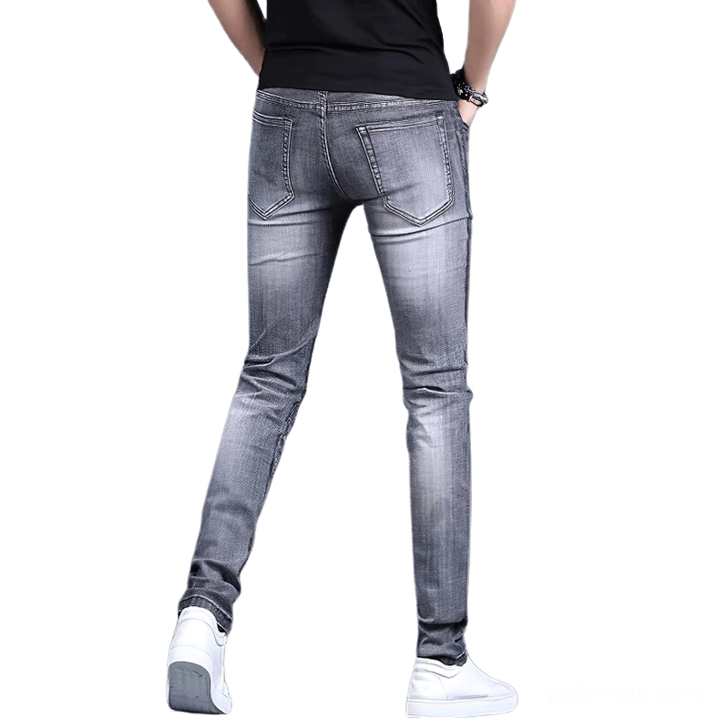Back view of gothic embroidered stretch denim jeans showing classic pocket design and full-length silhouette