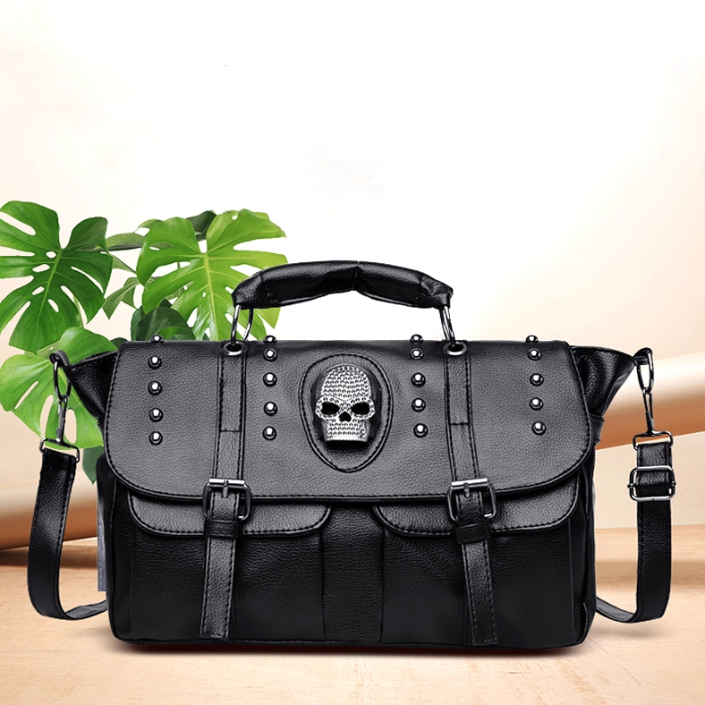 Black pebbled PU leather gothic handbag detail showing skull emblem and rivet decorations on studio display